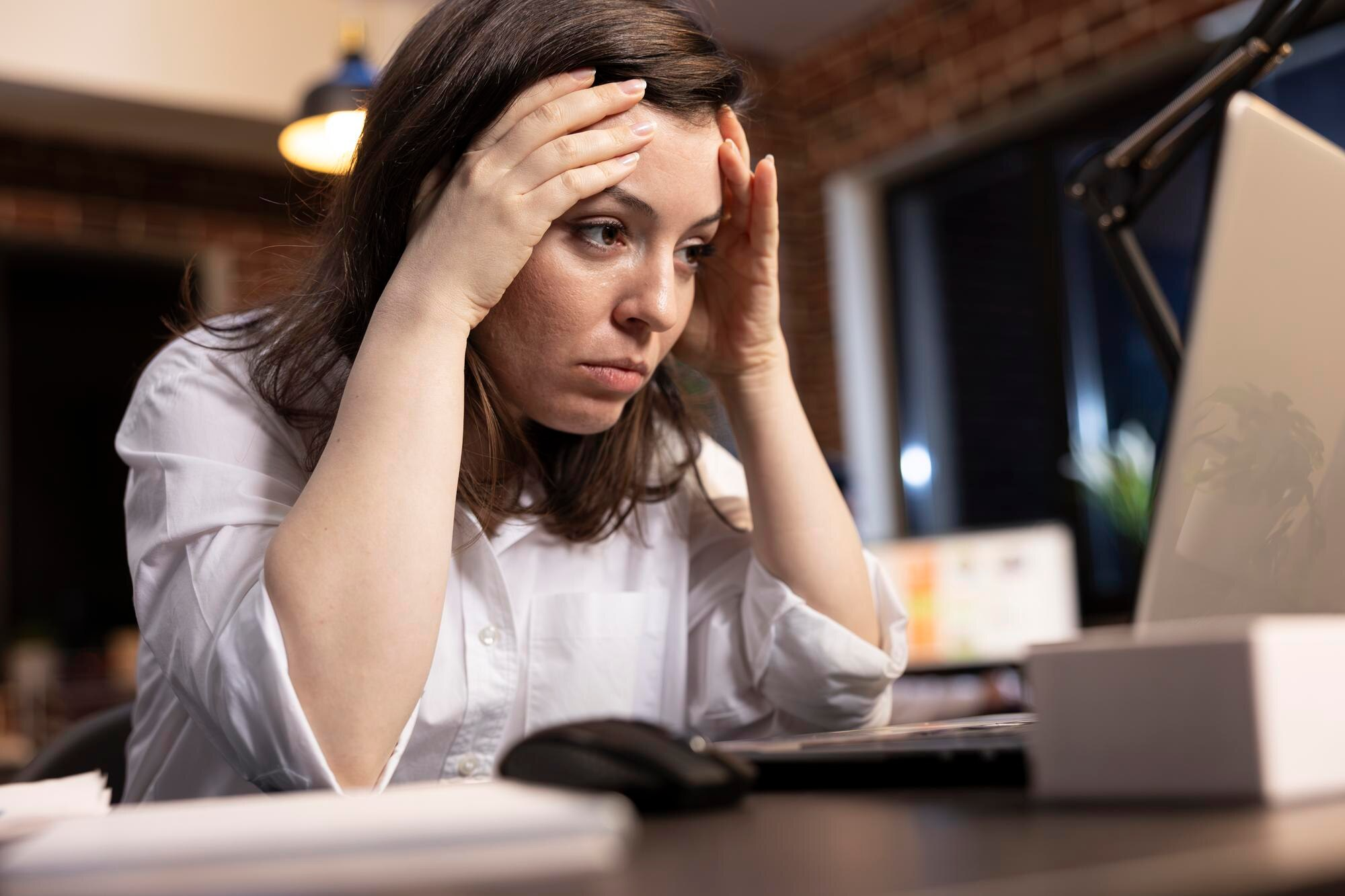 Mujer viendo una computadora estresada/Burnout crónico