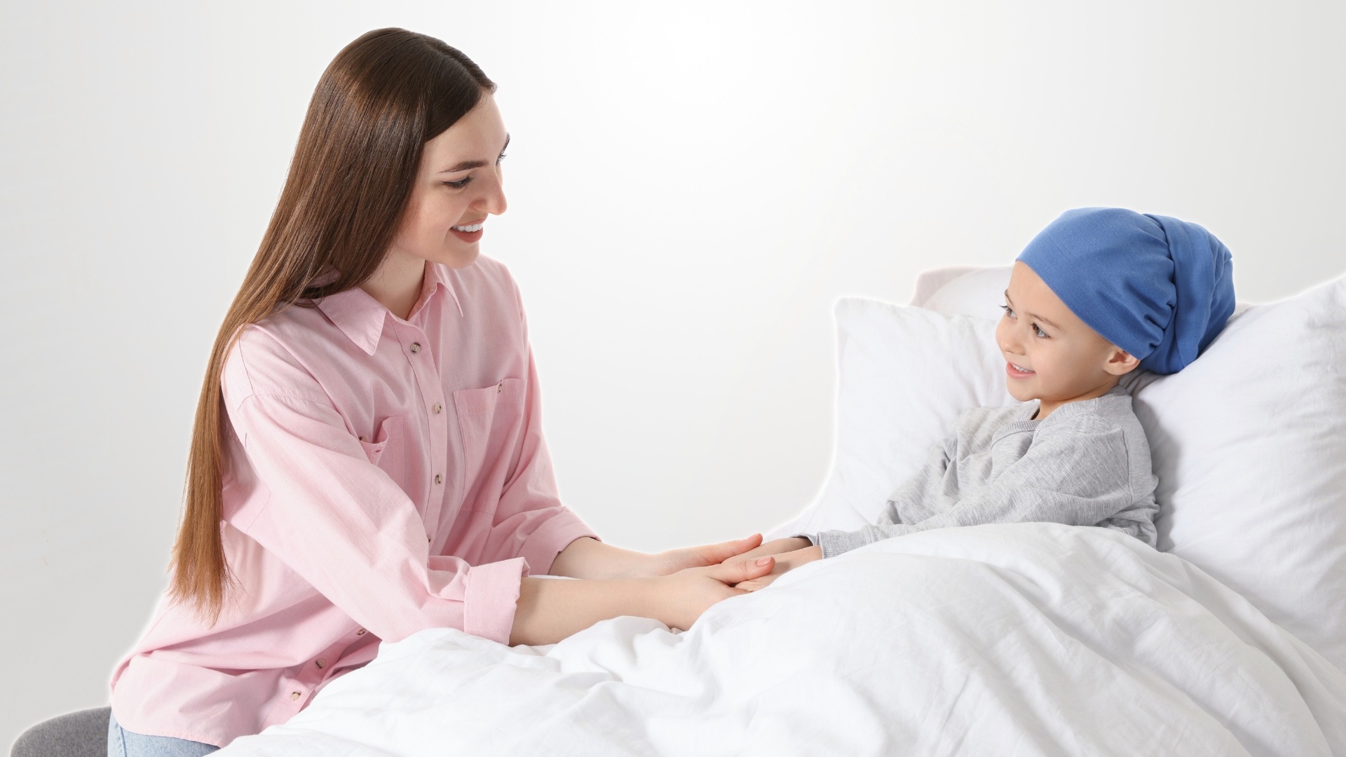 Mujer sonriendo a niño con cáncer infantil